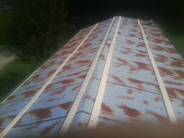 Rusted metal roof panels with new wood purlins before replacement — Storm Damage Roof Repair in Snook by Roofing Brothers