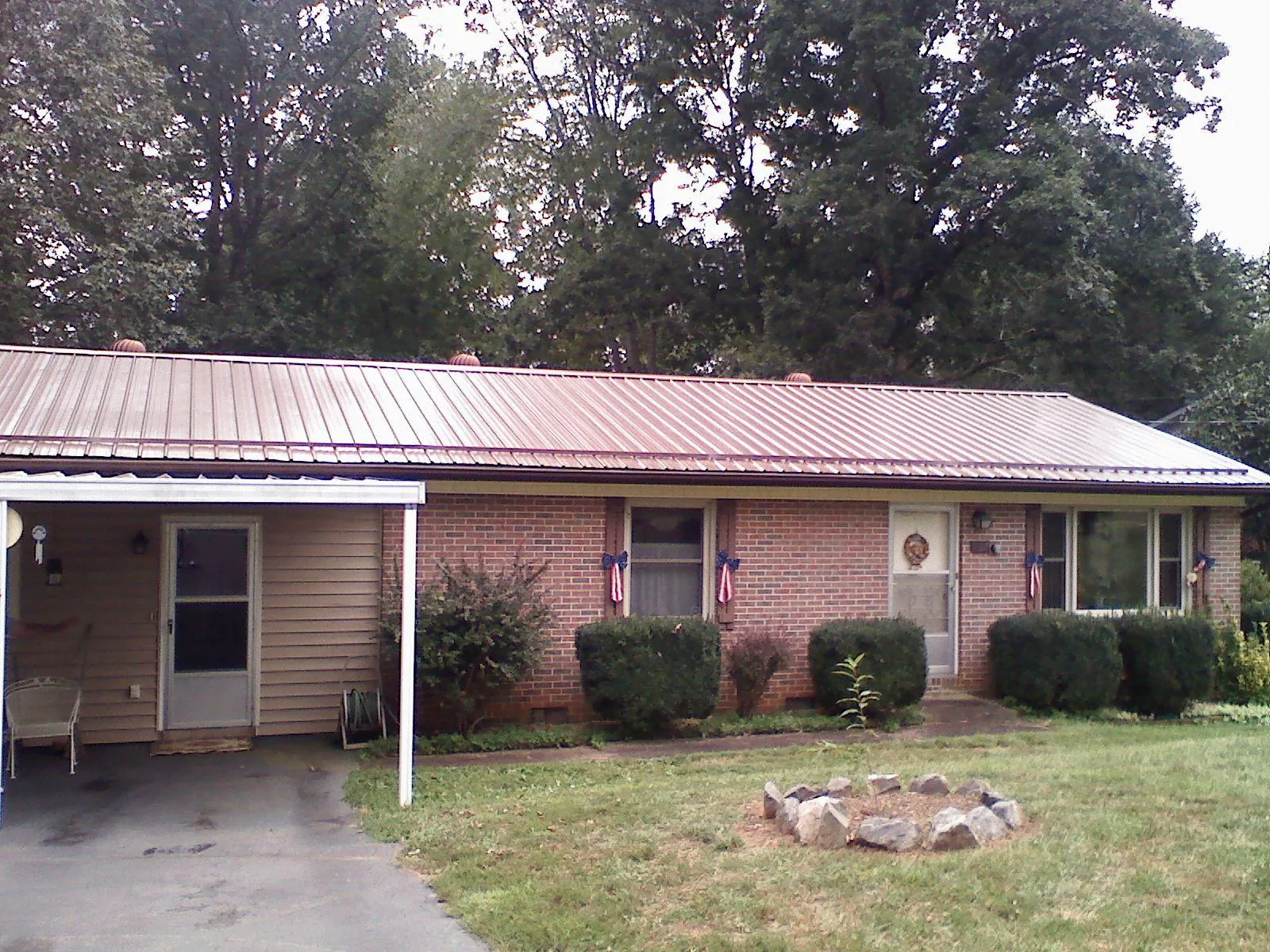 Bronze metal roof and carport on a brick ranch home — Roof Repair work by our crew in Snook