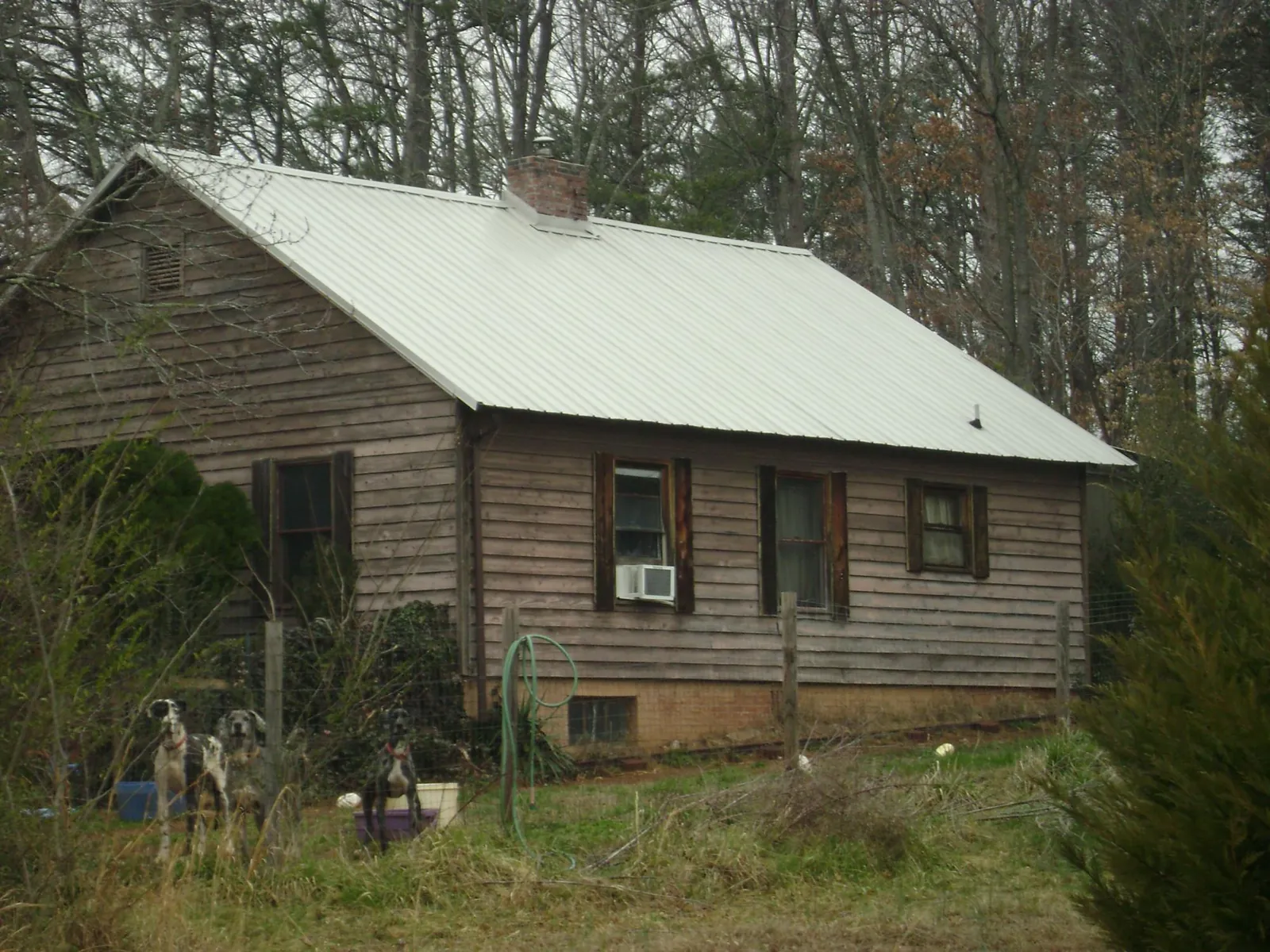 White metal roof on an old wood sided farmhouse, from a Metal Roof Installation job in Snook